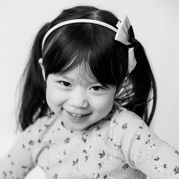 Black & White kids photo on a white backdrop - little girl with pigtails by Paper Bunny Studios