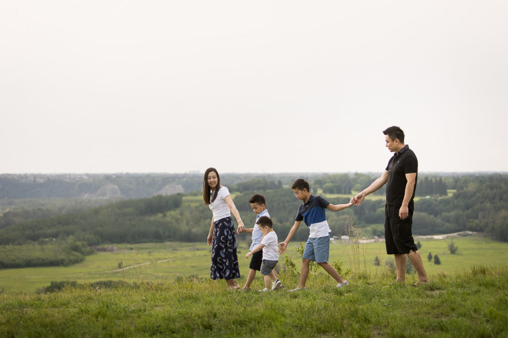 Documentary outdoor family photography of family walking by river by Paper Bunny Studios Edmonton