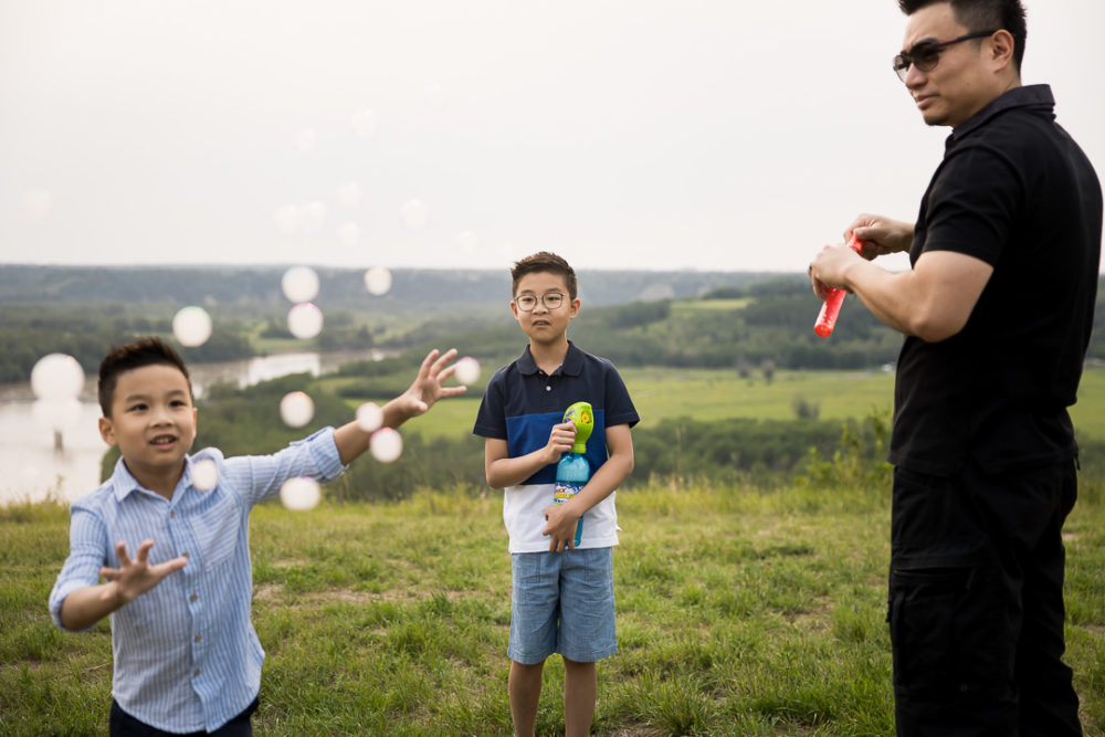 Edmonton outdoor documentary family photography of dad & boys playing with bubbles by Paper Bunny Studios