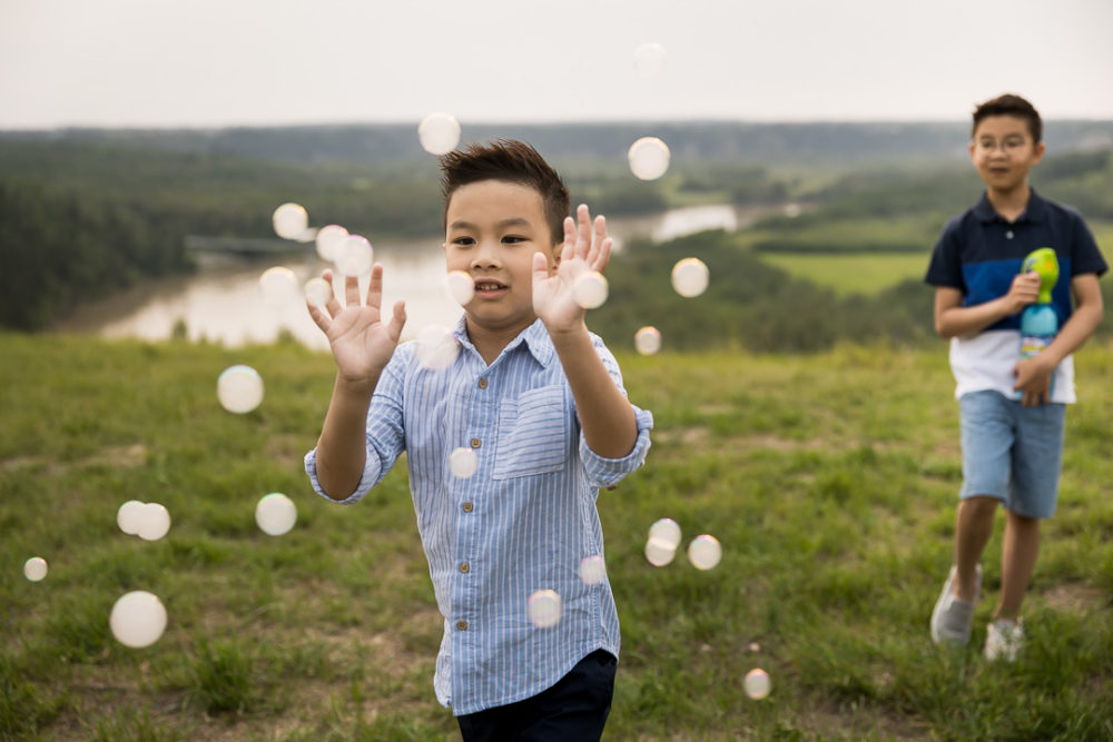 Edmonton outdoor documentary family photography of young boy playing with bubbles by Paper Bunny Studios