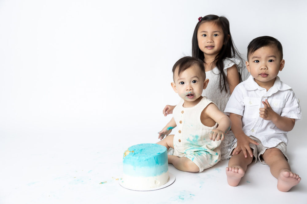 First Birthday Cake Smash photography - baby & older siblings  around cake by Paper Bunny Studios Edmonton
