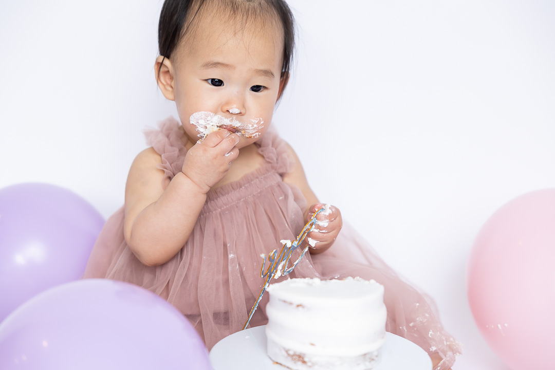 First birthday cake smash photography - baby eating cake by Paper Bunny Studios Edmonton
