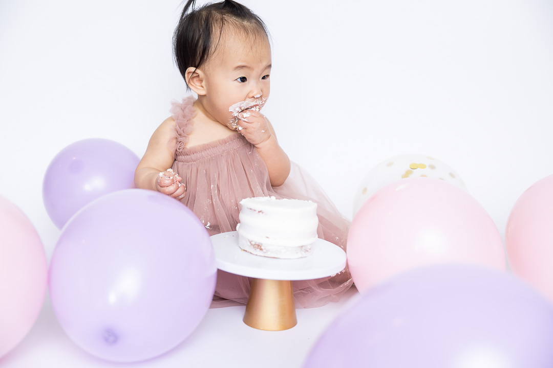 First birthday cake smash photography - baby eating cake by Paper Bunny Studios Edmonton