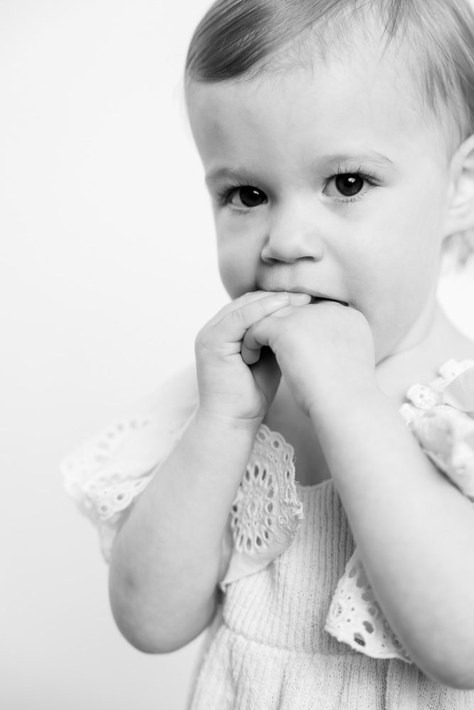Toddler black & white portrait photography little girl with hands in mouth by paper bunny studios Edmonton