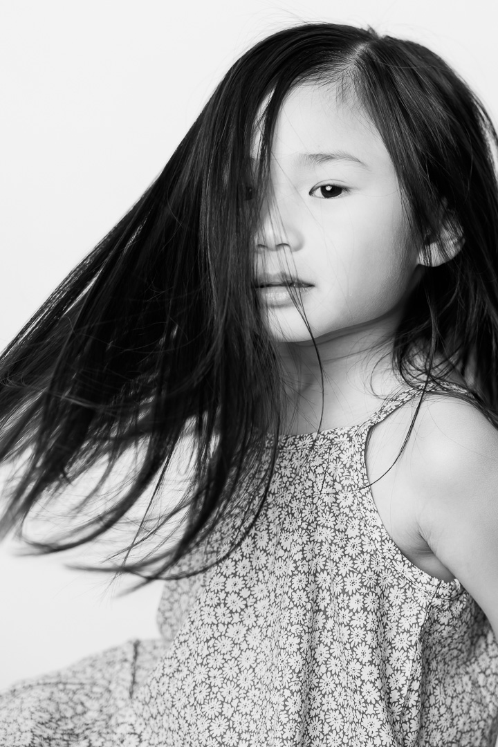 Artistic black & white children's portrait photography of girl with movement in long hair by Paper Bunny Studios Edmonton