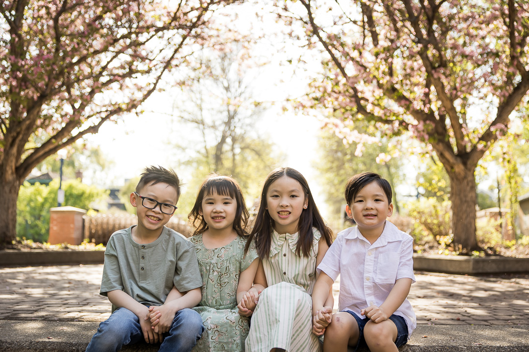 Happy cousins sat together for outdoor family portrait by Paper Bunny Studios