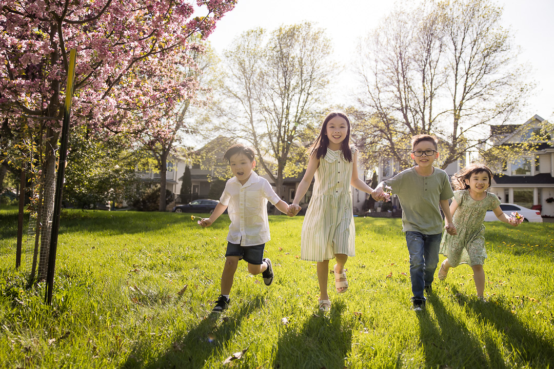 Cousins holding hands & running for extended outdoor family photo by Paper Bunny Studios Edmonton