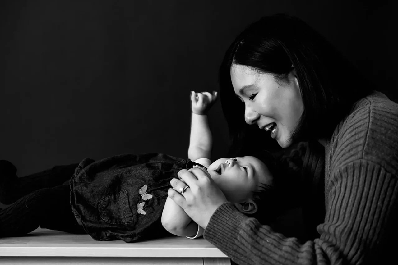 Mother's day black & white portrait on a black background of mum and baby by paper bunny studios