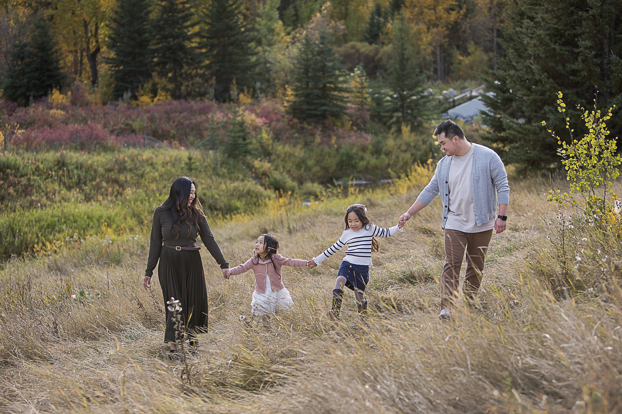 Outdoor fall family photos of family walking while holding hands by Edmonton family photographer Paper Bunny Studios