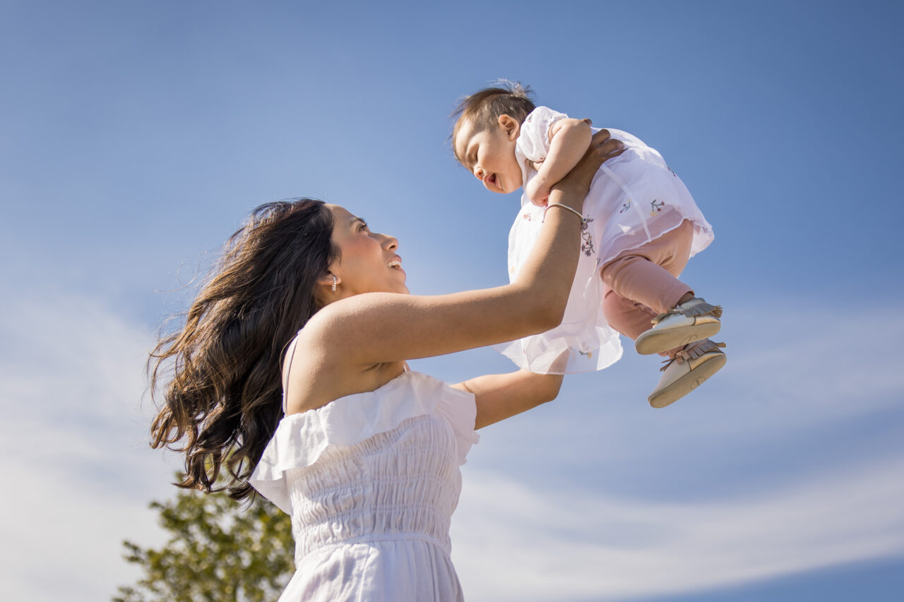 Mom lifting baby up in air by documentary family photographer Paper Bunny Studios