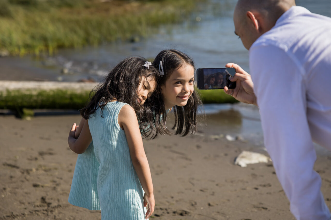 Dad taking a candid photo of daughters by documentary family photographer Paper Bunny Studios
