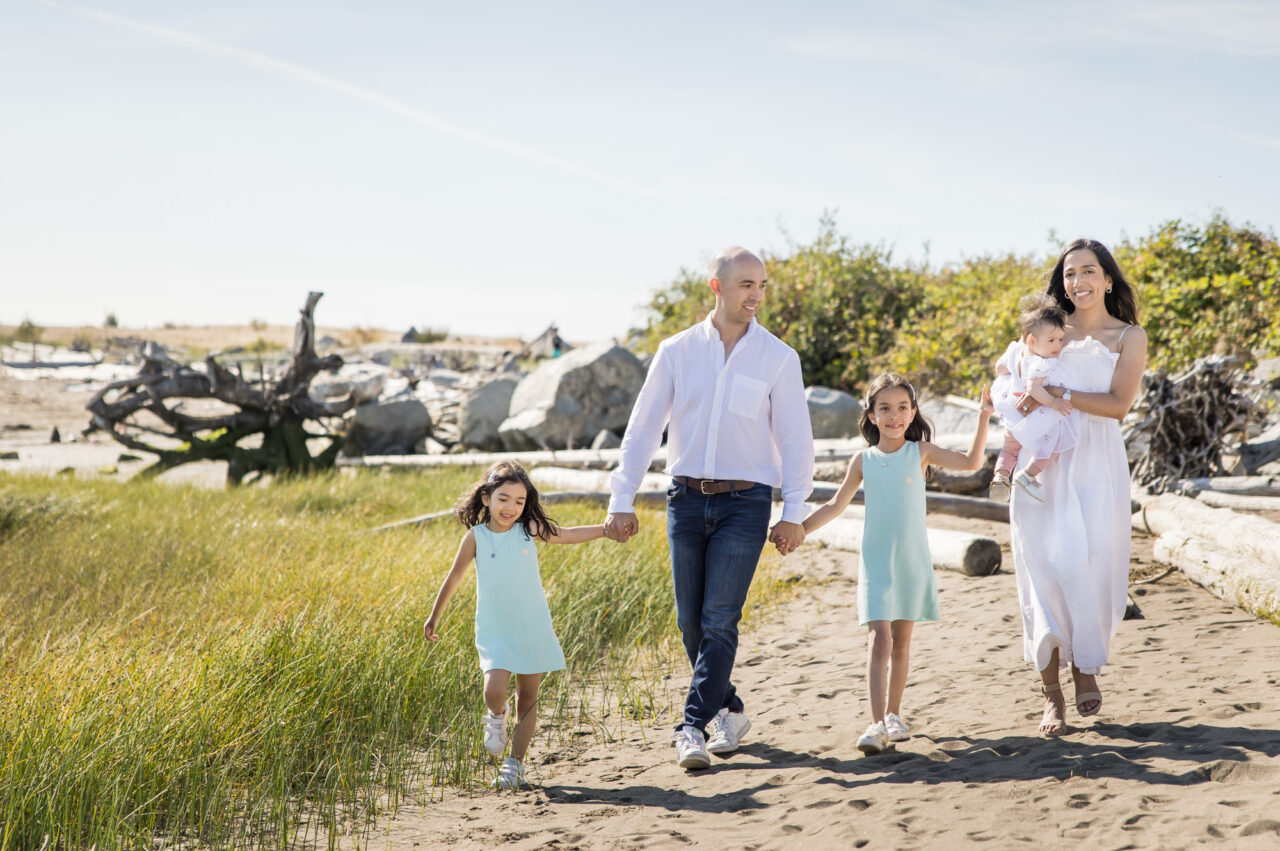 Family strolling on beach by documentary family photographer Paper Bunny Studios