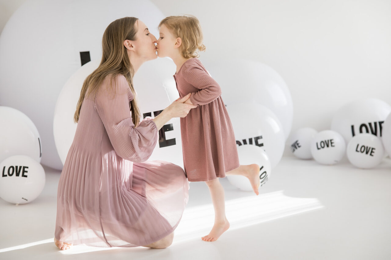 Mom + Me mini session with Paper Bunny Studios using giant beach balls saying LOVE on them as a backdrop. Image copyright Paper Bunny Studios